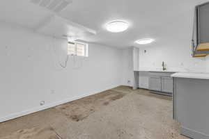 Below grade area with baseboards and a textured ceiling