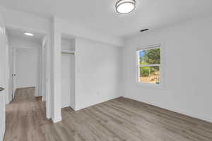 Unfurnished bedroom featuring light wood-type flooring and a closet