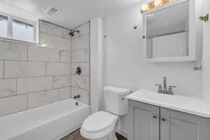Bathroom with shower / washtub combination, vanity, and a textured ceiling