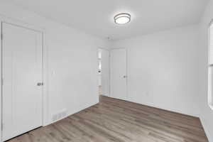 Unfurnished bedroom with wood finished floors and baseboards
