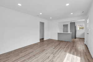Unfurnished living room with light wood-style flooring and recessed lighting