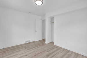 Unfurnished bedroom with light wood-style floors and a closet