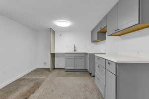 Kitchen with gray cabinets and concrete floors