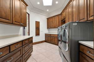 Washroom with light tile patterned floors, recessed lighting, cabinet space, independent washer and dryer, and ornamental molding