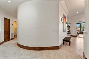 Hall with arched walkways, recessed lighting, and light tile patterned flooring