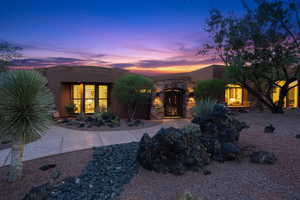 View of exterior entry featuring stone siding and stucco siding