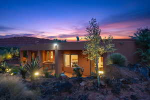 View of front facade with a patio and stucco siding
