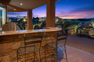 Patio terrace at dusk featuring grilling area