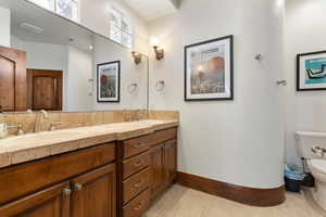 Bathroom with double vanity and light tile patterned flooring