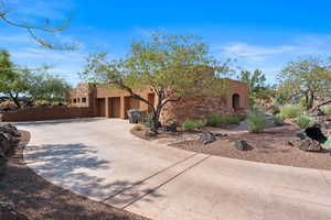 View of front facade with stucco siding, an attached garage, concrete driveway, and stone siding