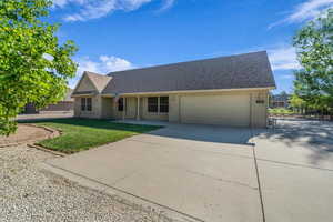 View of front of home with driveway, a shingled roof, stucco siding, an attached garage, and a front yard