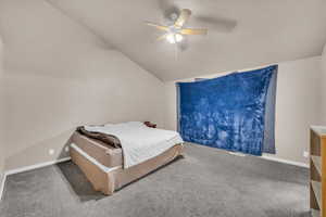 Carpeted bedroom with vaulted ceiling and ceiling fan