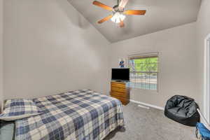 Bedroom featuring carpet floors, lofted ceiling, and ceiling fan