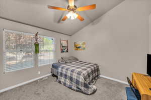 Bedroom featuring vaulted ceiling, carpet floors, and ceiling fan