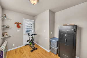 Workout area featuring light wood-style floors and a textured ceiling