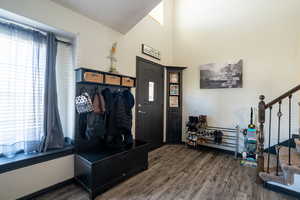 Entrance foyer featuring wood finished floors, stairs, and a towering ceiling