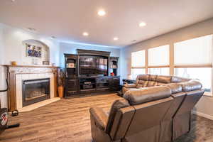 Living room featuring recessed lighting, a tile fireplace, and wood finished floors