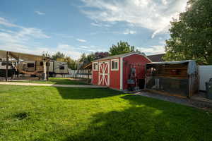 View of yard featuring a trampoline, exterior structure, and a storage unit