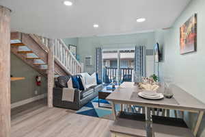 Living area with stairway, light wood-style flooring, and recessed lighting