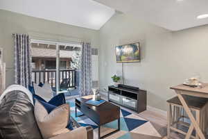 Living room featuring vaulted ceiling and wood finished floors