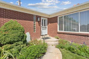 Doorway to property featuring brick siding