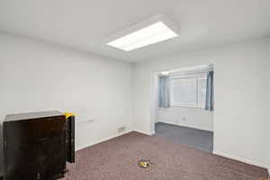 Carpeted spare room with baseboards