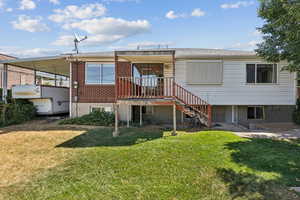 Back of property featuring a yard, stairway, and brick siding