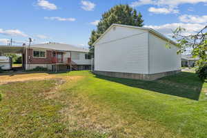 View of side of property featuring a yard and brick siding