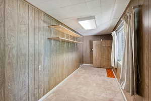 Mudroom with wooden walls and light colored carpet
