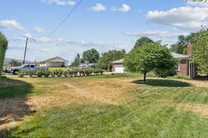 View of green lawn with a garage