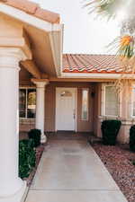 Entrance to property with a tiled roof and stucco siding