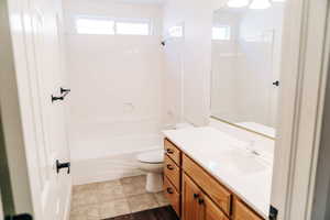 Full bath featuring vanity, shower / bathtub combination, and light tile patterned floors