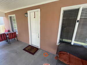 Entrance to property featuring stucco siding and a porch