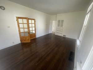 Empty room with dark wood finished floors and french doors