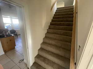 Stairs featuring tile patterned floors and baseboards
