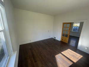 Unfurnished room with dark wood-style floors and baseboards