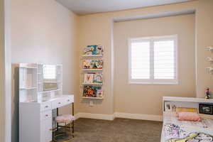 Bedroom featuring multiple windows and dark carpet