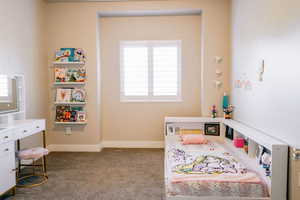 Bedroom featuring light carpet and baseboards
