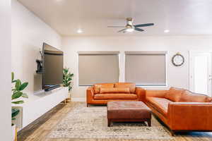 Living room with wood finished floors, ceiling fan, and recessed lighting