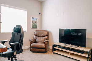 Home office featuring light carpet and baseboards