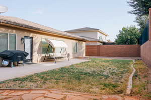 Rear view of house with stucco siding, a patio, and a fenced backyard