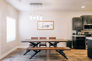 Dining room with light wood-type flooring and recessed lighting