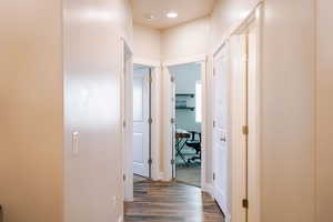 Hallway with dark wood-style floors and an office area