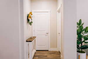 Hallway featuring dark wood-style flooring and baseboards