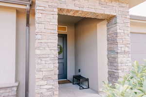 View of exterior entry featuring stucco siding and stone siding