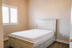 Bedroom with dark carpet and baseboards