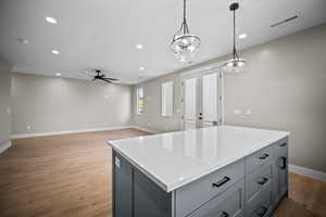 Kitchen featuring french doors, recessed lighting, decorative light fixtures, a kitchen island, and gray cabinets