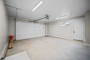 Garage with baseboards and a garage door opener