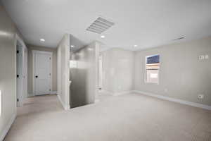 Empty room with carpet and recessed lighting