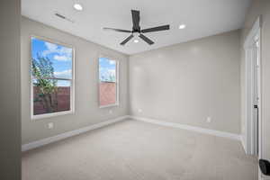 Unfurnished bedroom with light colored carpet, ceiling fan, and recessed lighting
